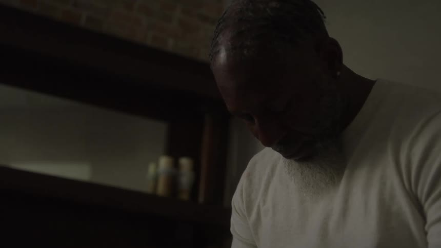 Man with his head down in an indoor setting with soft lighting