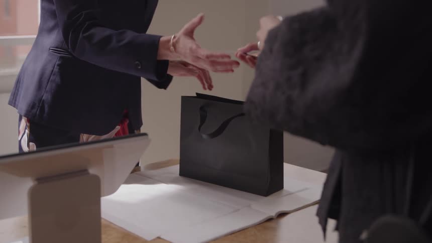Person swiping a card at a payment terminal on a table