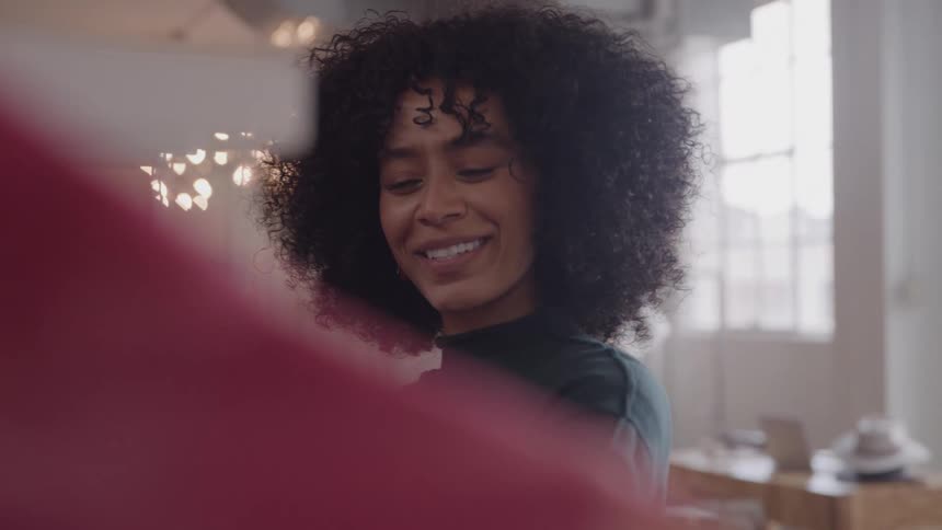 A smiling woman looks at a fashionable dress in a clothing store