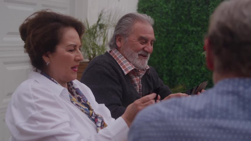 Older man and woman look at their cards during a game