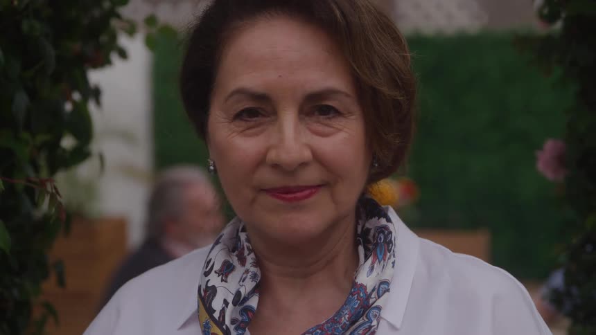 An elegant older woman with a gentle smile looking directly into the camera
