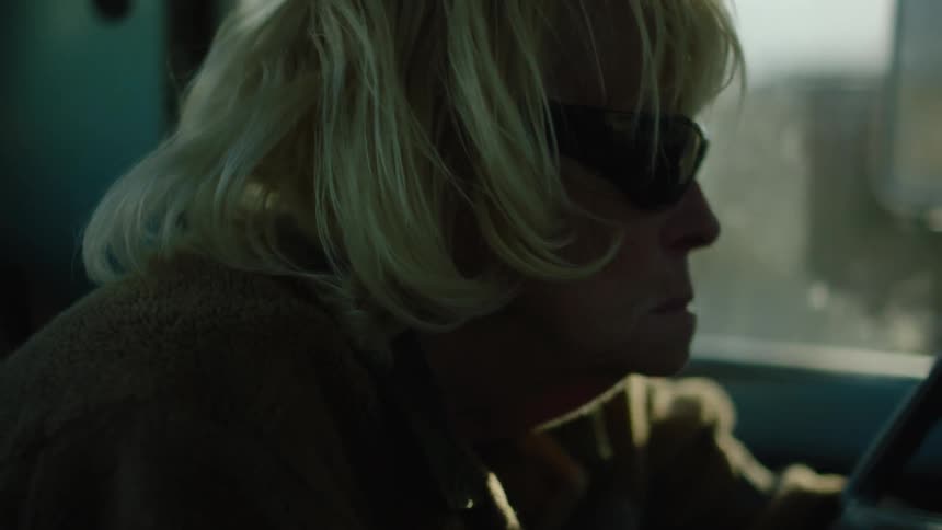 A woman is steering a car looking forward