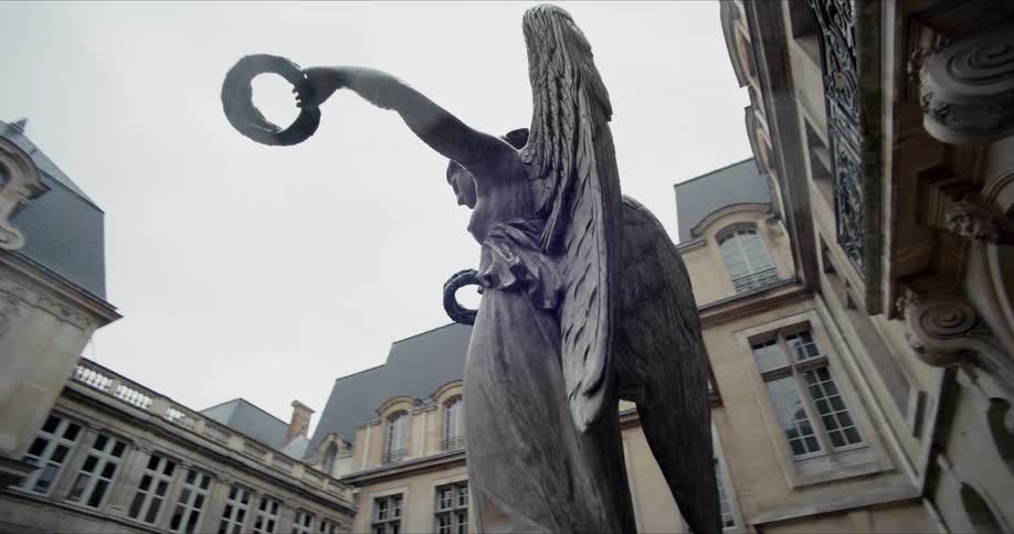 Statue of an angel surrounded by an old building outdoors during day time