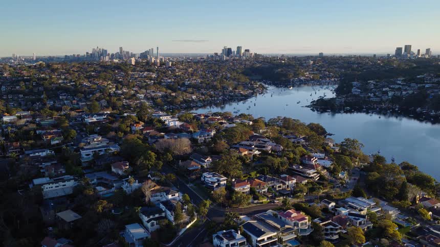 Suburban neighborhood next to a lake with a metropolitan area on the background outdoors during dusk or dawn