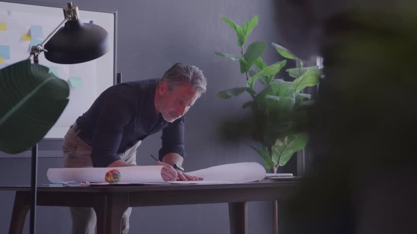 Man performs manual work on large desk in modern office setting