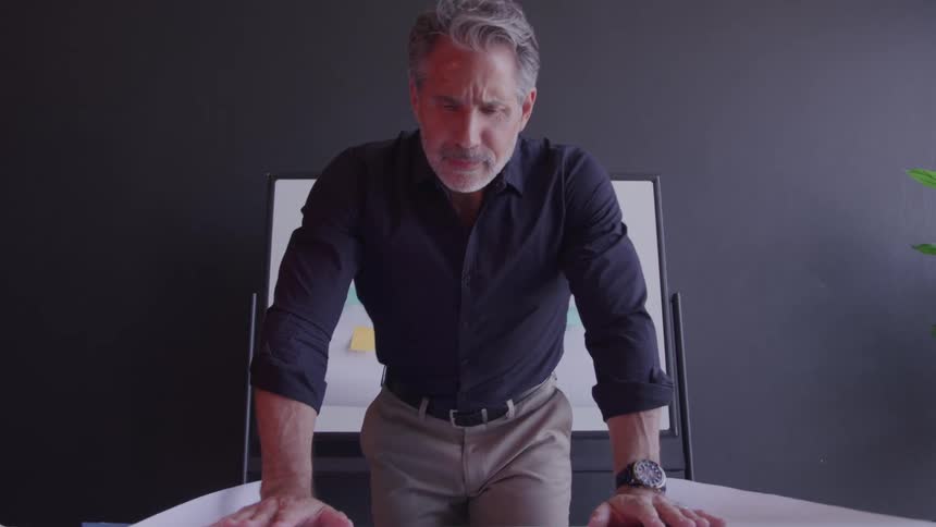 Man carefully analyzes a project spread out on the desk