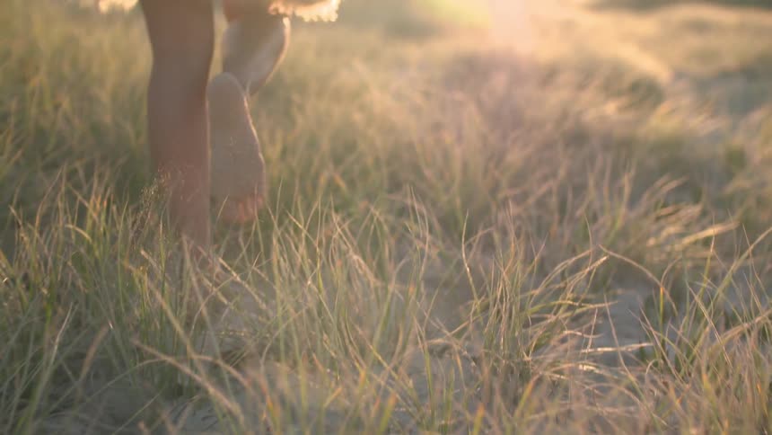 Woman walking barefoot in the grass