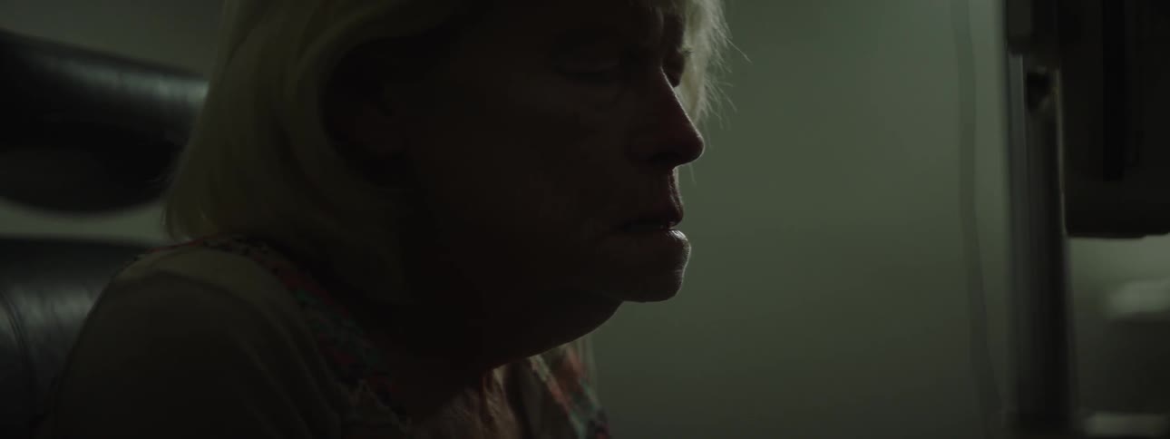 A woman looks around in a dark room