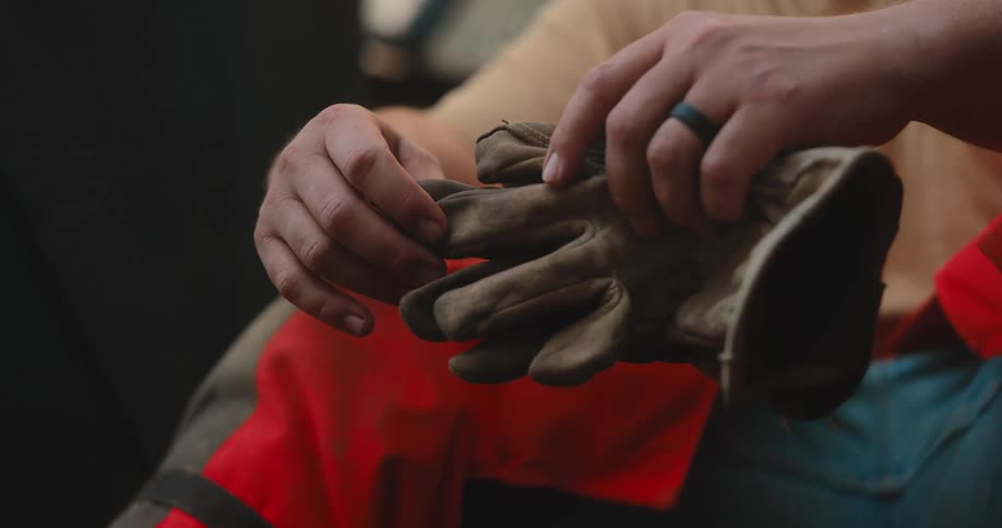 Man holds a pair of work gloves before starting the task