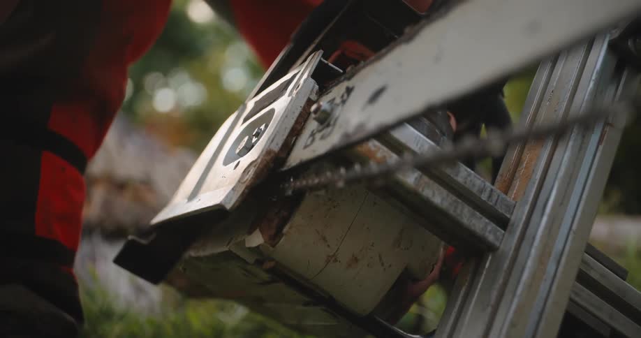 The man is tightening a bolt on the machine