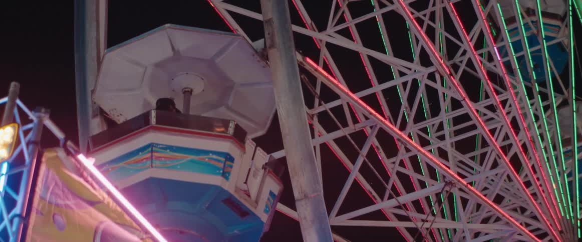 People are riding on the ferris wheel at night