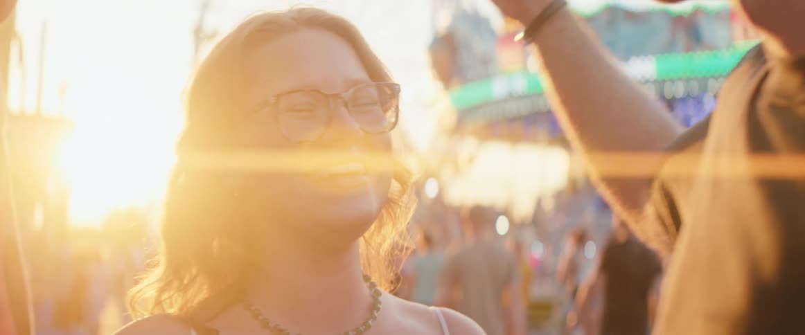 Woman smiles leaning on her partner under the golden sunset light