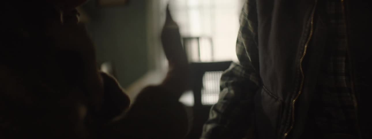 A couple hold hands in a dark room
