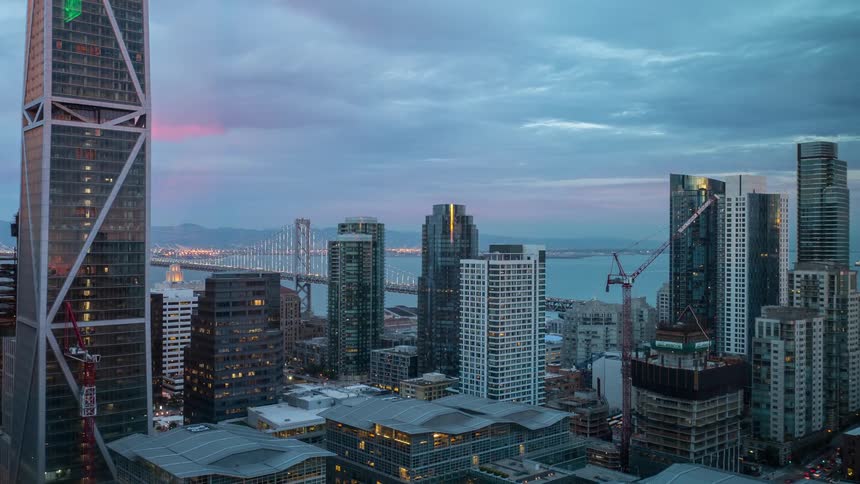 City lights begin to glow as dusk settles over the skyscrapers