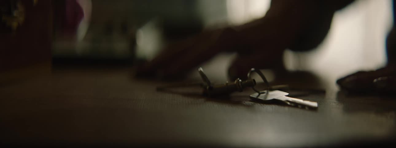 A person picks up a set of keys from the table