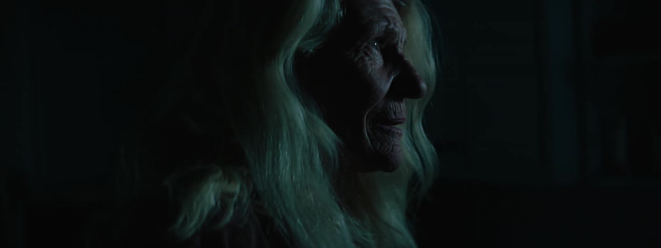 An elder woman looking around in a dark space