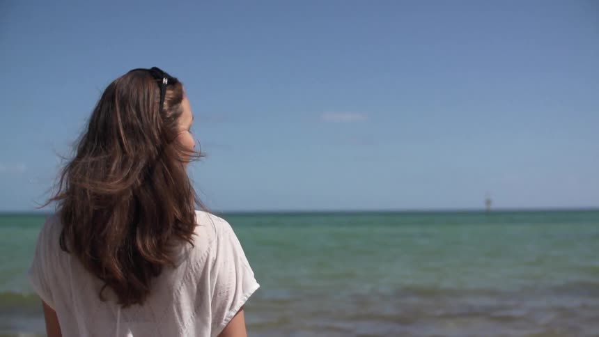 Woman facing the ocean on a clear day