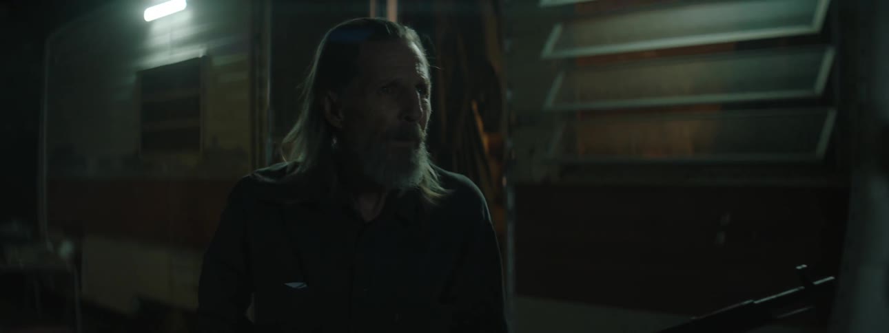 A man exits a home with a rifle