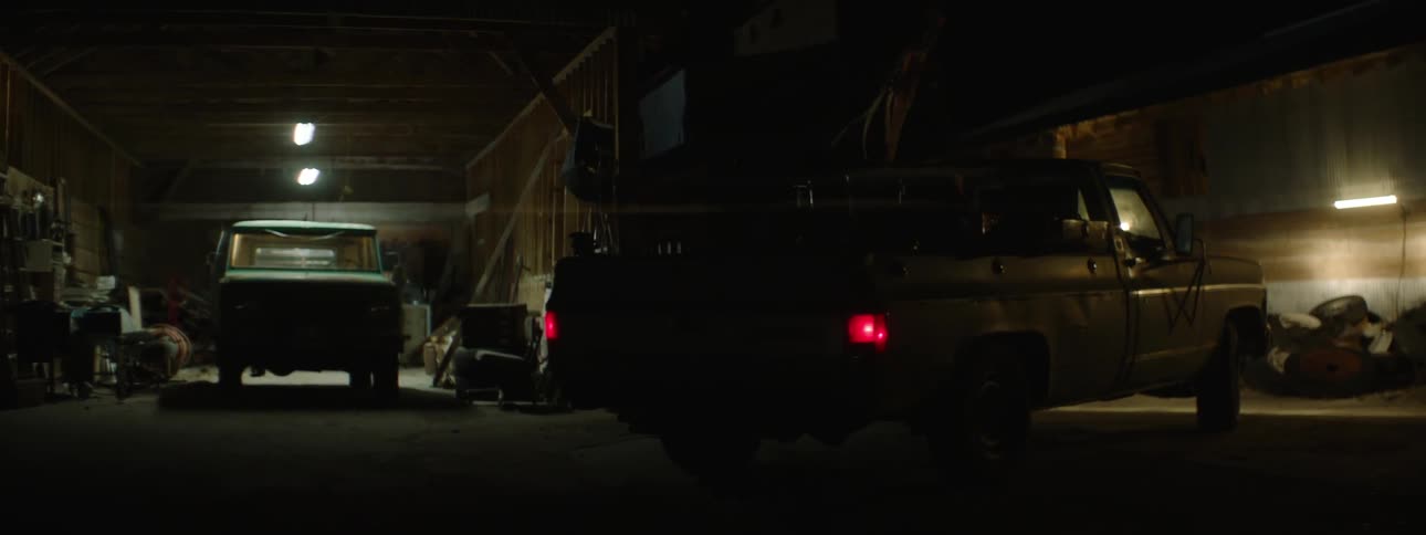 A truck pulls into a dark garage