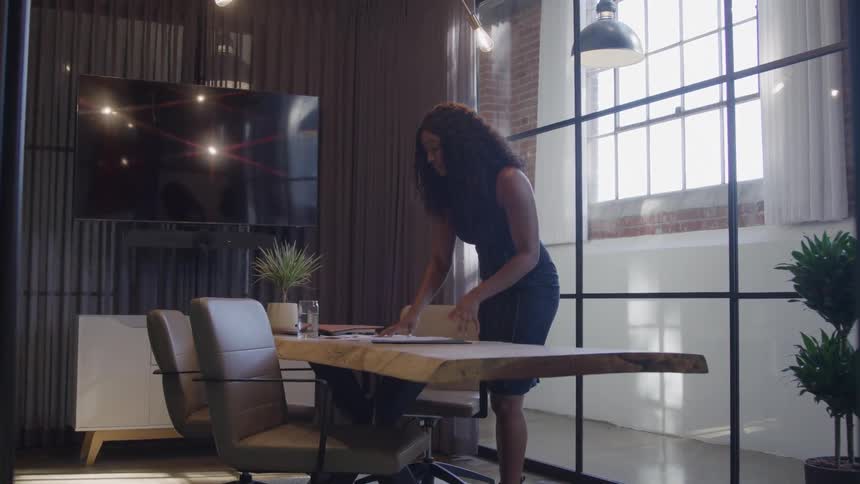 A woman tosses papers off a desk