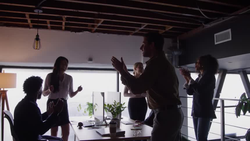 Coworkers celebrate in the office and clap