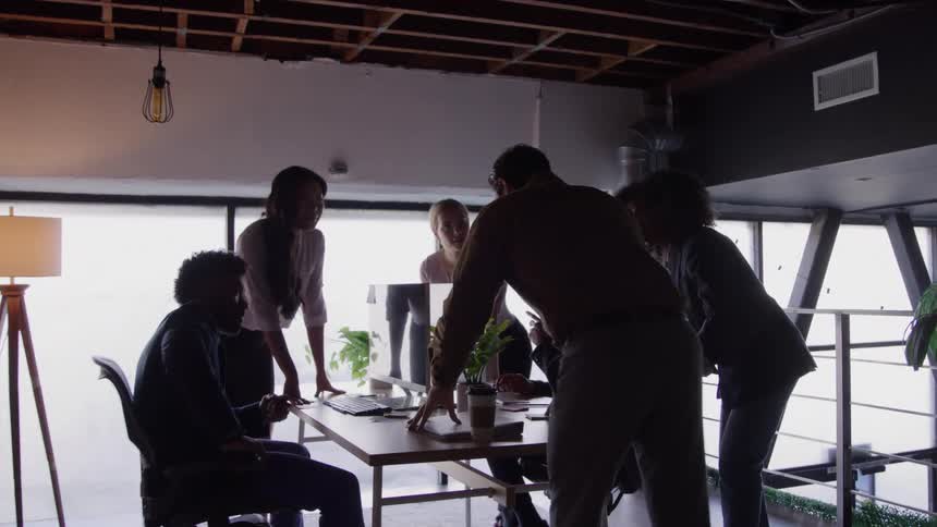 Colleagues discuss ideas together during a meeting in the office