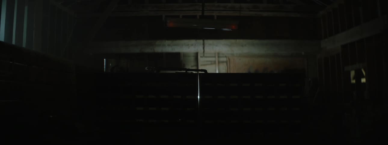 A fluorescent ceiling light in a workshop flickers on and off