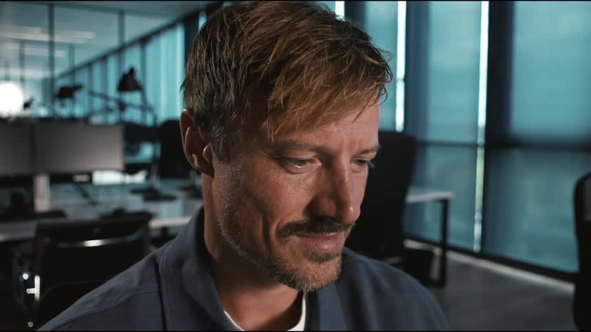 close up of the man working at his desk, being satisfied and happy with what hes looking at