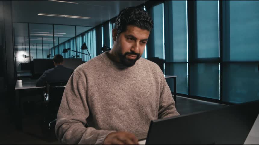 man happily sends away an email