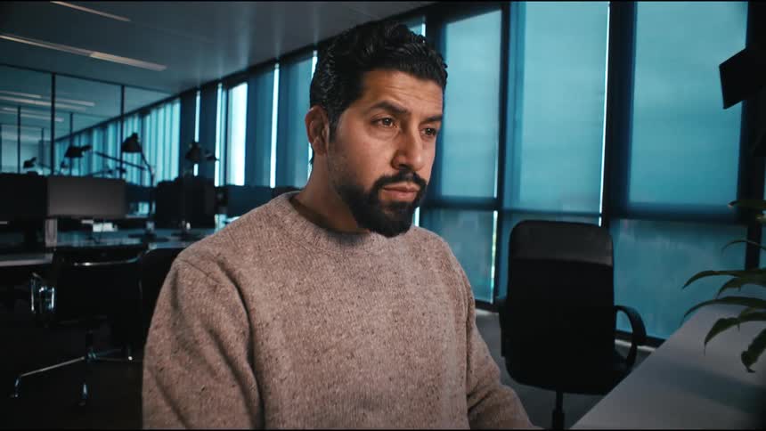 a man is working concentrated at his computer in an office setting