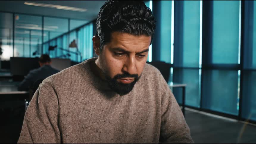 The man thinks then leans in to use his laptop