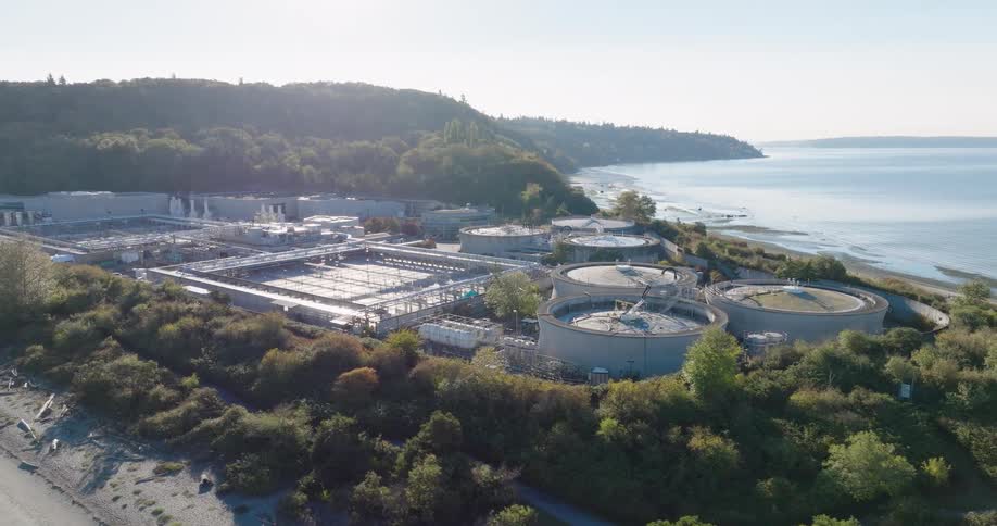 Low orbit around a municipal water treatment plant as various equipment and tanks reflect the morning sun