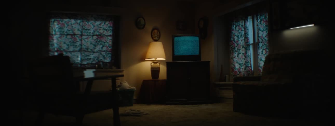 A television displays static in a dark room