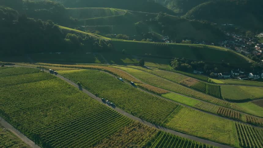 Green fields and winding roads in a mountainous landscape at sunset