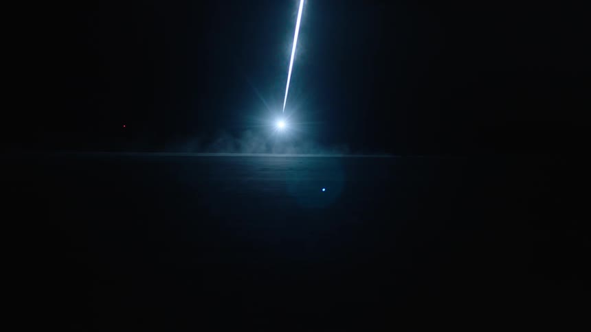 A car drives by a bright light at night
