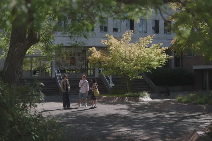 Teenagers are talking together in front of the school