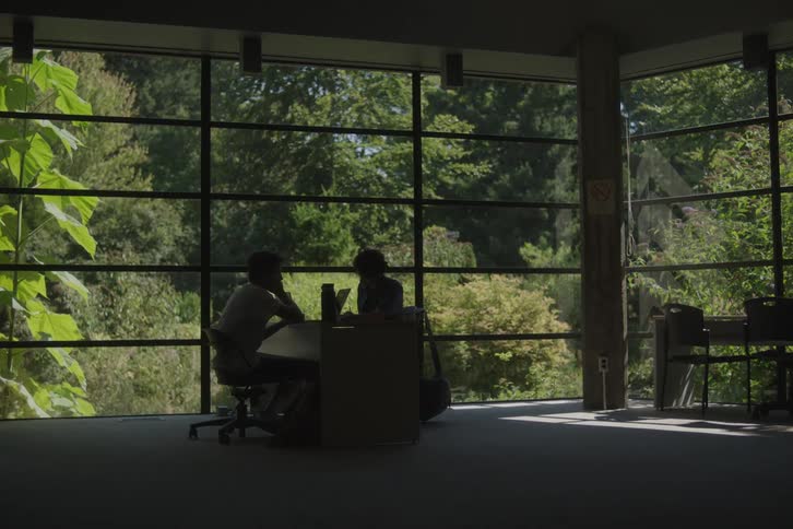 Two people talk at the desk in the office