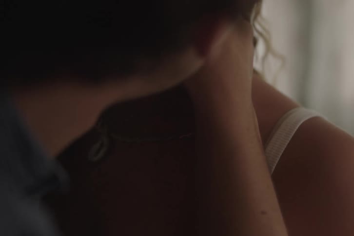 Person caressing anothers neck in an intimate moment