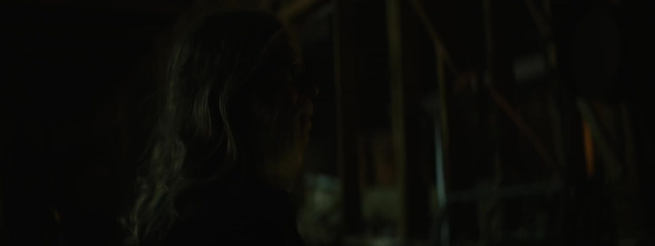 A man looks around at a dark area