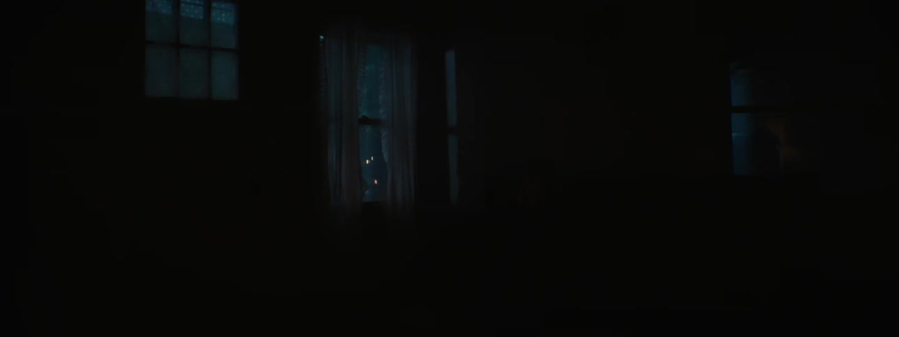 Person sitting on a couch watching lights flash by a window at night