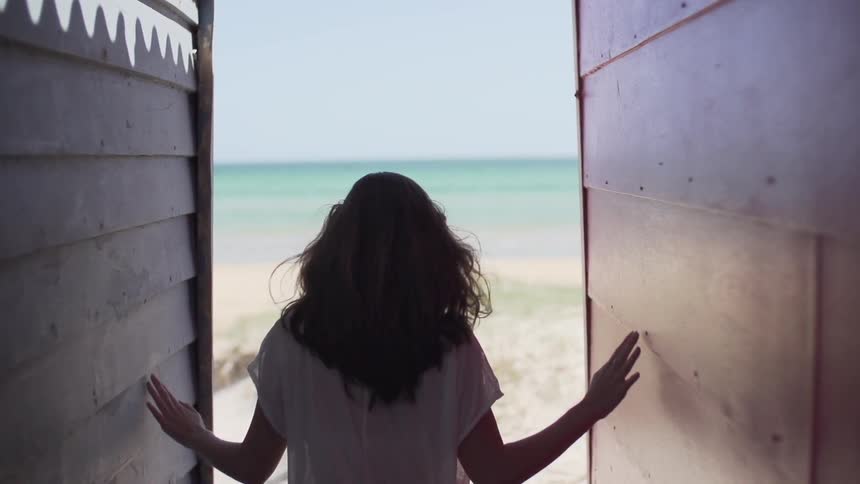 Woman walking towards the ocean
