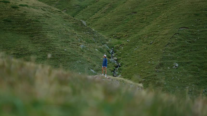 Person walking through a grasscovered valley
