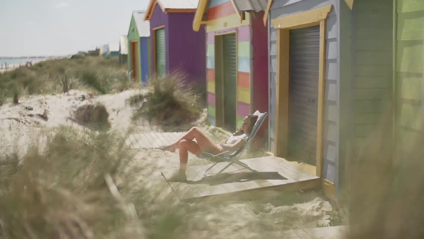 A woman sitting on a beach chair on a sunny day