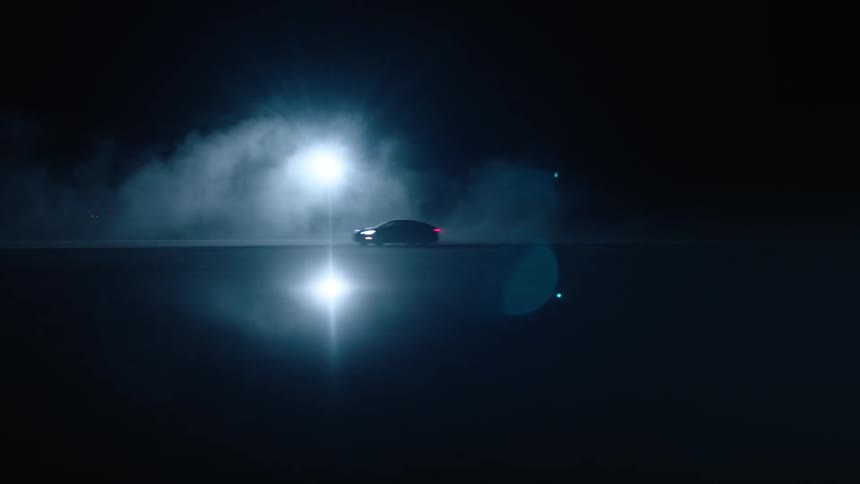 A car drives down a dark road