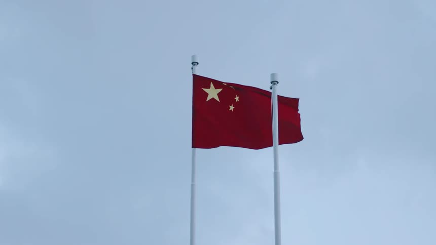 Flag of china waves in the wind under a clear sky