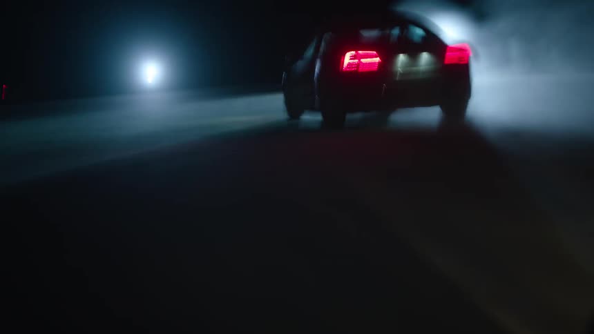 A car drives by bright lights at night