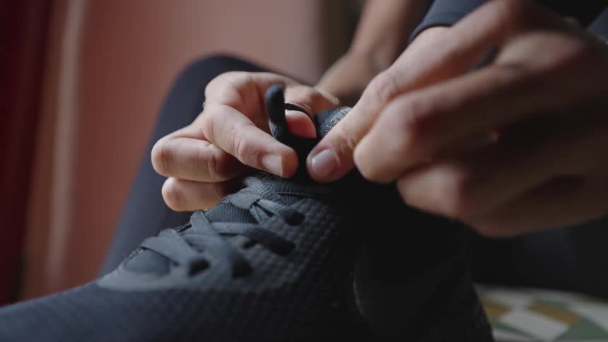 Close up of a young person tying their sneaker laces