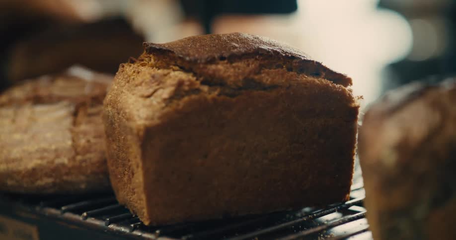 Row of bread loaves exposed in a metal rack indoors