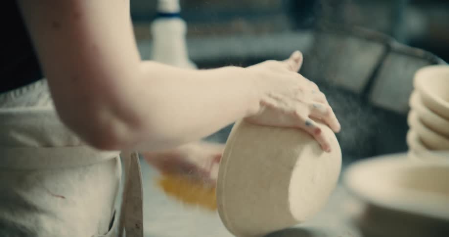 Close up of a young woman cleaning baking bowls in a kitchen
