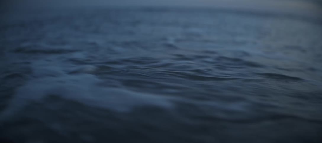 Ocean waves gently crash against the shoreline at sunrise